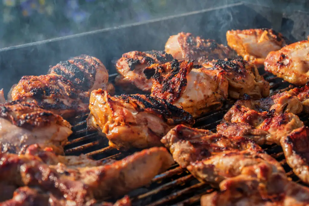 Barbecue chicken with crispy skin on a charcoal grill on a sunny day