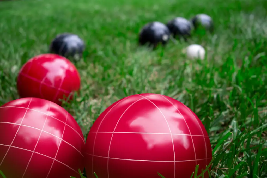 Close-up of red and black bocce balls in the grass