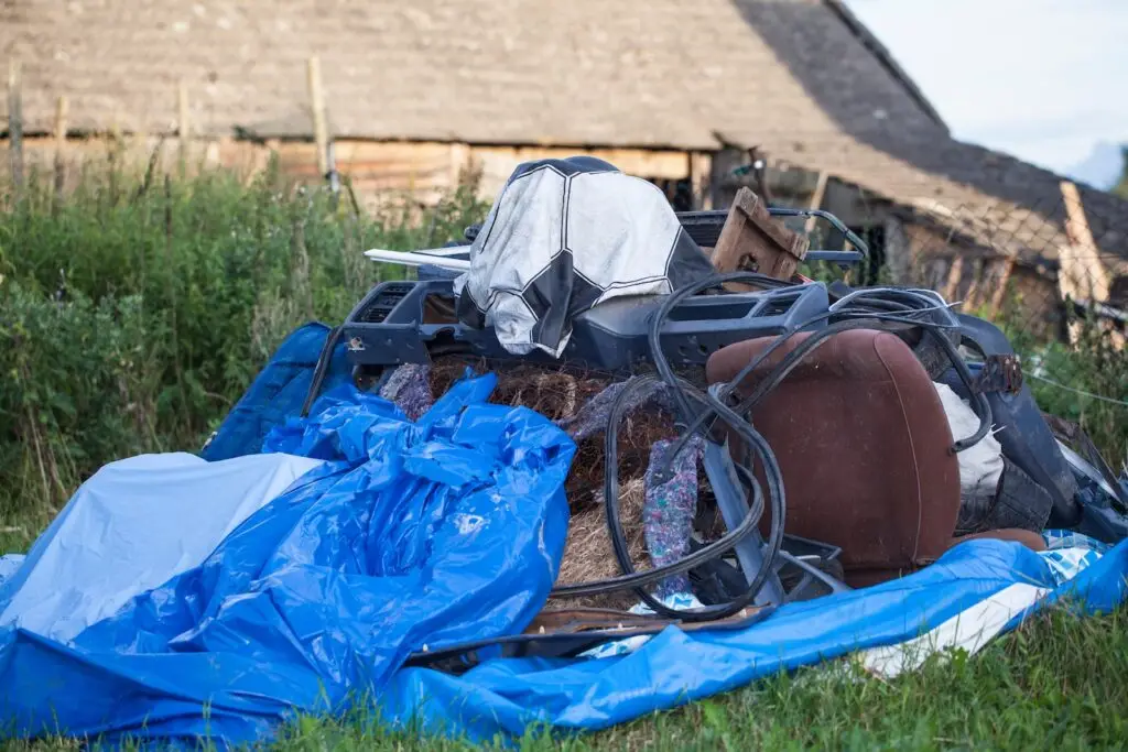 A tarp and a pile of junk in a backyard