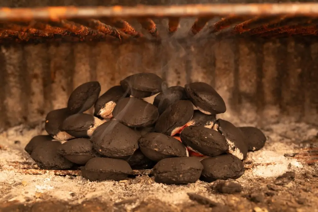 Charcoal briquettes in a pile in a barbecue grill