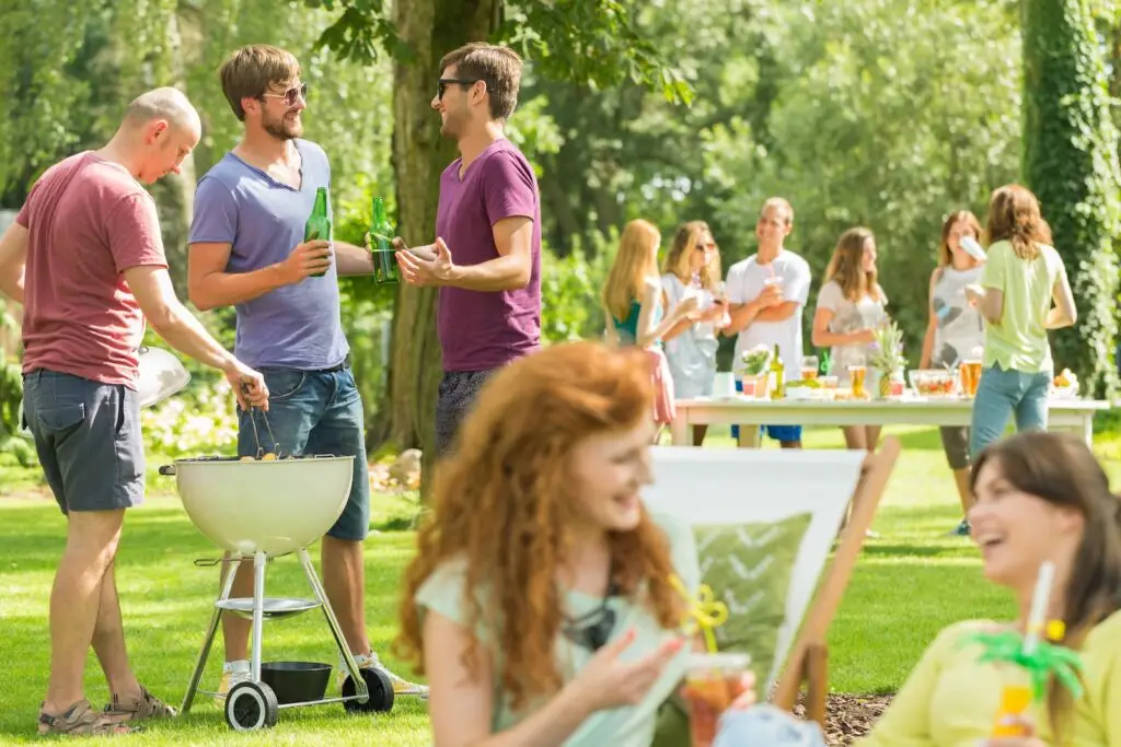 Friends having a casual conversation around a barbecue grill